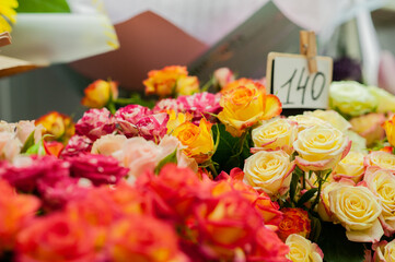 Yellow and red roses in the window of a flower shop. Flowers in the refrigerator. Small business. Selective focus.