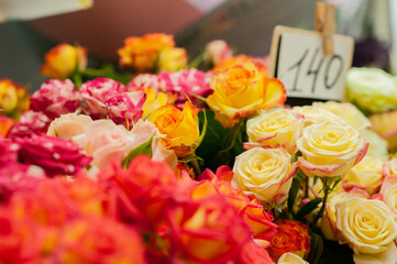 Yellow and red roses in the window of a flower shop. Flowers in the refrigerator. Small business. Selective focus.