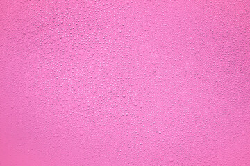 Water or rain drops on pink plastic sheet background 