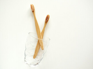 Bamboo toothbrushes are eco-friendly in a glass with a copy of the space on a white background. Zero waste. Free plastic. Top view.