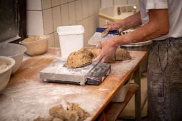  a baker portions the bread dough into equally sized pieces