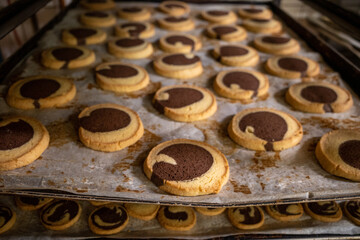many fresh baked goods are on baking trays in a bakery
