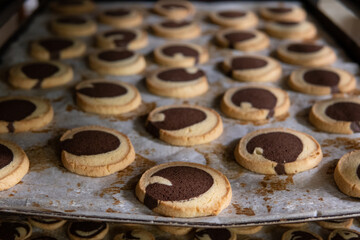 many fresh baked goods are on baking trays in a bakery