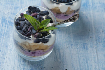 cheesecake cake with cottage cheese cream, honeysuckle berries, mint leaf in a glass