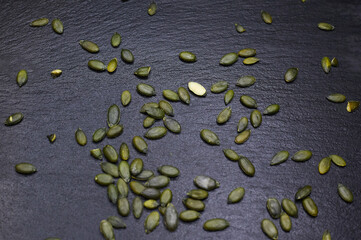 green pumpkin seeds on a black background