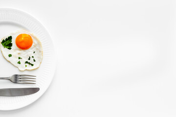 Fried eggs on plate - white dinner table from above copy space