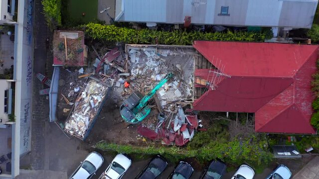 Top down view of excavator demolishing house