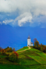 Fototapeta premium St Primoz church in Slovenia under deep blue sky with big white clouds