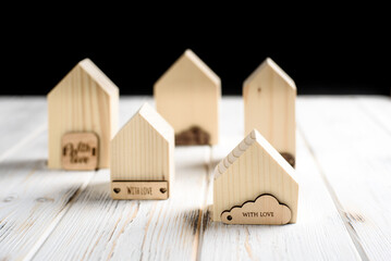 Close up view of wooden small house figures on the bright wooden background, the concept of an environmentally friendly estate