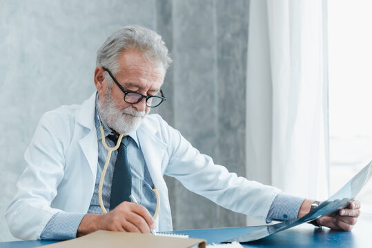 Orthopedic Doctor Checkup Exam X-Ray Film in Clinic Patient Examination Room, Professional Orthopedics Surgery Physician Specialist Doctor is Diagnosis Patients Bone With XRay Scan. Healthcare/Medical