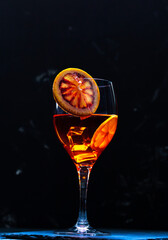 Aperol Spritz cocktail with blood orange on dark background