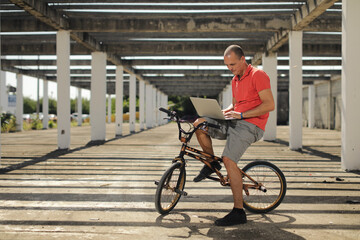 BMX rider on the bike looking at notebook outside on the street, urban style.