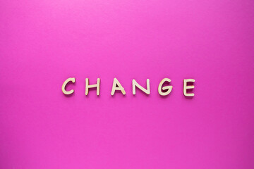 Change words written by wooden letters on a color background. Top view