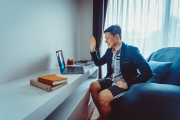 Young Asian Businessman wear Formal Suit with Short Pants Having Video Conference Meeting with...