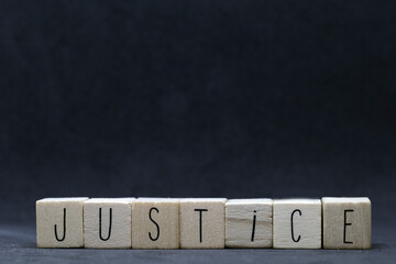 Wooden cubes with the word Justice on black background, Black lives matter concept