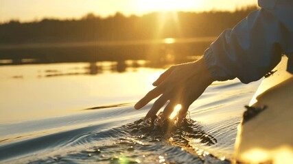 man puts fingers down in lake kayaking against backdrop of golden sunset, unity harmony nature - Powered by Adobe
