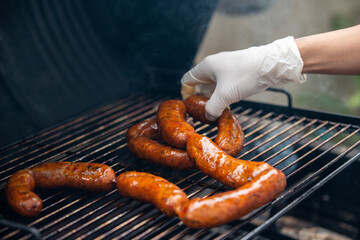 Street food. A man cooking sausages on the grill.