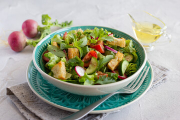 Fattoush salad, green vegetables, herbs, tomato, radish and pieces of toasted pita bread. Lebanese cuisine