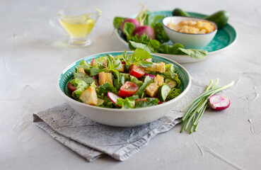 Fattoush salad with lettuce, herbs, tomatoes, cucumber, red onion, radish and pieces of toasted pita bread. Middle Eastern cuisine.
