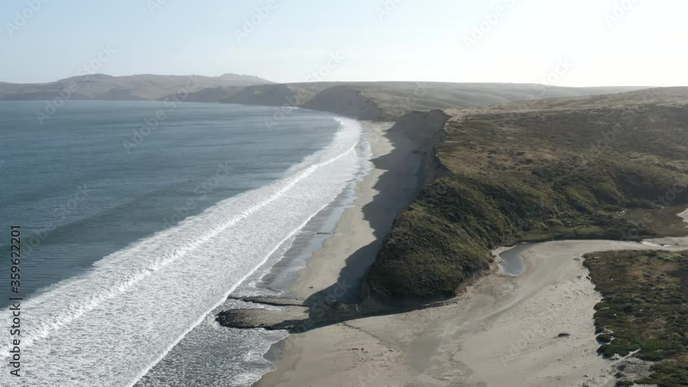 Aufkleber aerial parallax shot of waves washing in on empty point reyes beach in daylight
