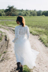 Fototapeta na wymiar bride in white dress standing in green area