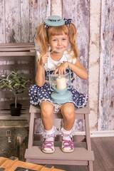 Portrait of little girl in retro vintage photographic studios.
