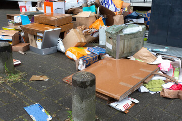 Large pile of garbage next to full container on filthy street, old paper
