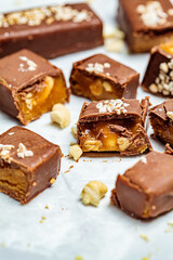 Raw vegan chocolate and caramel bars, white background. Healthy desserts concept.