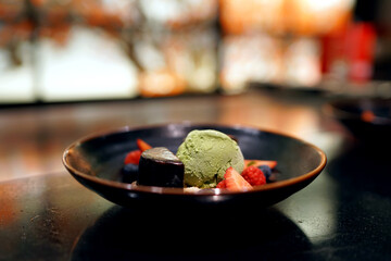 Matcha green tea ice cream with chocolate cake served with fresh strawberry, raspberry and blueberry, Selective focus.