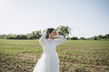 bride in white dress standing in green area