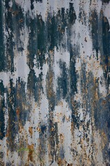 Old shabby paint with a blue tint on a metal background