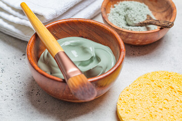 Clay mask in wooden bowl. Preparing a clay face mask. Skincare concept.