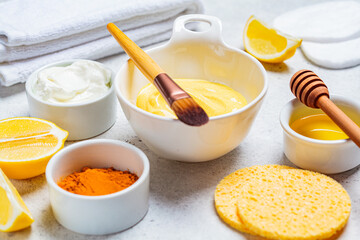 Preparation of turmeric face mask with honey and yogurt in white bowl. Skincare concept.