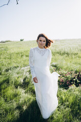 bride in white dress standing in green area