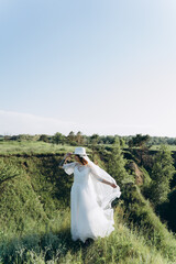 bride in white dress standing in green area
