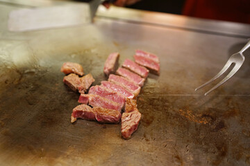 T-bone steak - Grilled beef on teppanyaki grill plate, Prepared for Teppanyaki style, Enjoy the spectacle of cooked to perfection by personal chef. Traditional Japenese steakhouse.