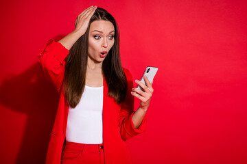 Photo of attractive business successful lady browsing telephone hand on head read amazing good news open mouth wear blazer pants suit isolated bright red color background
