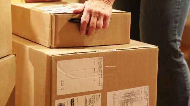 Man counting and verifying delivery card boxes.