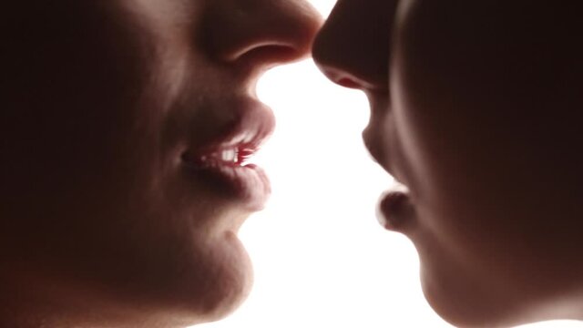 Passionate kiss of lesbian girls close-up. White isolated studio background. LGBT relationships.