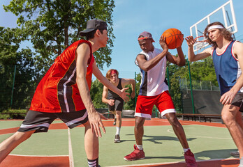 Diverse basketball team training for match at ourdoor sportsground © Prostock-studio
