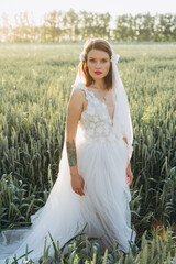 attractive woman wearing veil and long white dress standing in the field