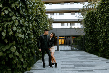 A young couple in love, a man and a woman walk through the evening city, spending time together.