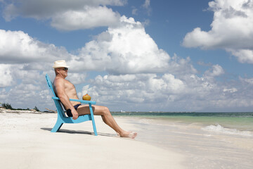 Obraz na płótnie Canvas man in chair on Caribbian beach
