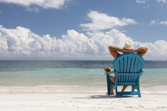 man in chair on Caribbian beach
