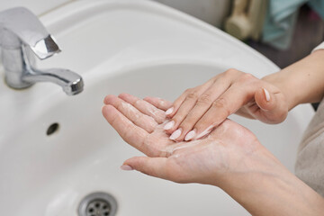 Personal hygiene concept. Woman washing hands with soap. Coronavirus or COVID-19 prevention. Hand washing process