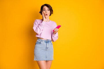 Portrait of astonished girl use cellphone read unexpected social media novelty impressed scream wow...