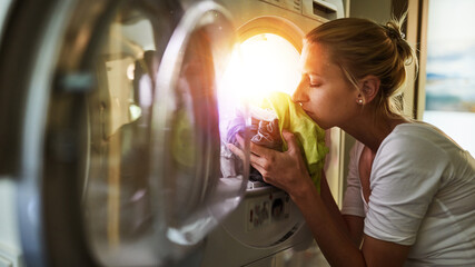 Woman smells clothes from the clothes dryer