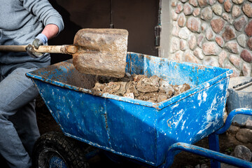 Man working with a shovel in clay.