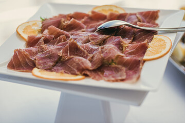 Close up gourmet seafood appetizer in a buffet. Smoked sliced salmon in a plate. Fresh and Healthy food concept.