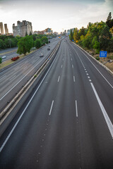 Cityscape from an empty motorway bridge at sunset, during confinement, in Madrid, Spain, vertically